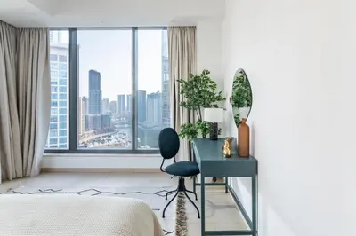 a bedroom with a desk and a large window at The Smart Concierge - Silverene in Dubai