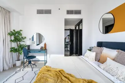 a bedroom with a bed and a desk and a chair at The Smart Concierge - Silverene in Dubai