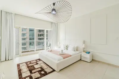 a white living room with a white couch and a window at RH- Urban Living, spacious 01BR, near burj Khalifa in Dubai