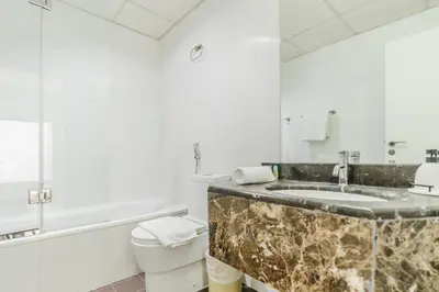 a bathroom with a marble sink and a toilet at RH- Urban Living, spacious 01BR, near burj Khalifa in Dubai