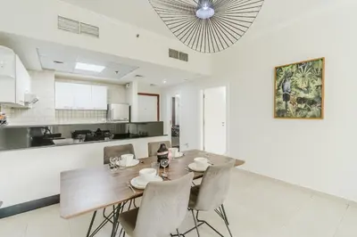 a kitchen and dining room with a wooden table and chairs at RH- Urban Living, spacious 01BR, near burj Khalifa in Dubai