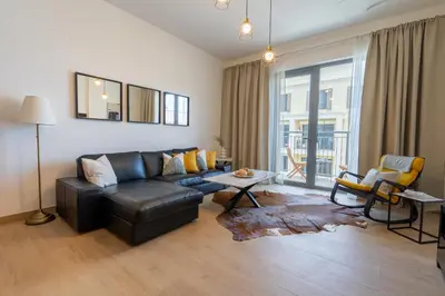 a living room with a leather couch and a table at HiGuests - Stylish Waterfront Retreat With Balcony in La Mer in Dubai