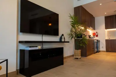 a living room with a large flat screen tv on a wall at HiGuests - Stylish Waterfront Retreat With Balcony in La Mer in Dubai