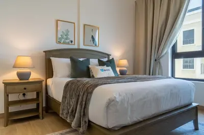 a bedroom with a large bed and a window at HiGuests - Stylish Waterfront Retreat With Balcony in La Mer in Dubai