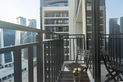a balcony with a chair and a vase of flowers at White Sage - DAMAC Zada Tower in Dubai