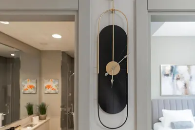 a clock hanging on a wall in a bathroom at White Sage - DAMAC Zada Tower in Dubai