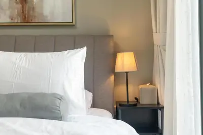 a bedroom with a white bed and a lamp at White Sage - DAMAC Zada Tower in Dubai