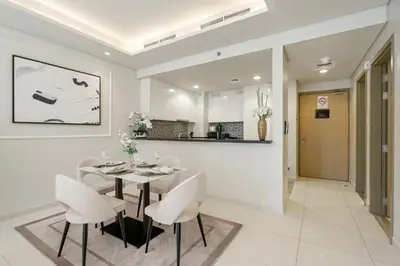 a dining room with a table and white chairs at Stunning 2BR with Burj Views Infinity Pool in Dubai