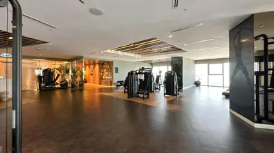 a gym with treadmills and exercise equipment in a building at Stunning 2BR with Burj Views Infinity Pool in Dubai