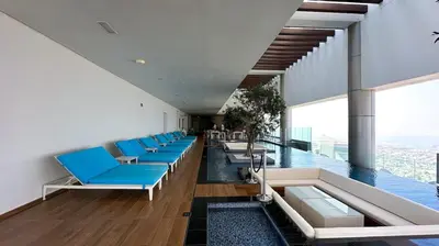 a room with blue chairs and a swimming pool at Stunning 2BR with Burj Views Infinity Pool in Dubai