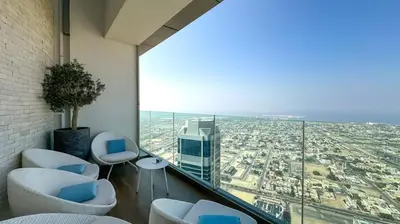 a balcony with chairs and a view of a city at Stunning 2BR with Burj Views Infinity Pool in Dubai