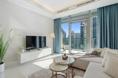 a living room with a couch and a tv at Stunning 2BR with Burj Views Infinity Pool in Dubai