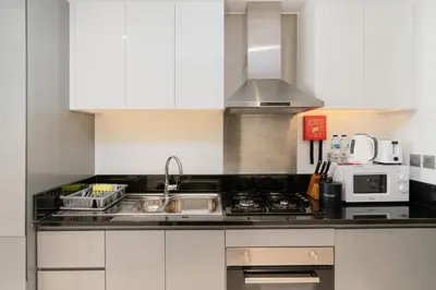 a kitchen with a sink and a stove at White Sage - Fancy Studio With Mesmerizing Canal Views in Dubai