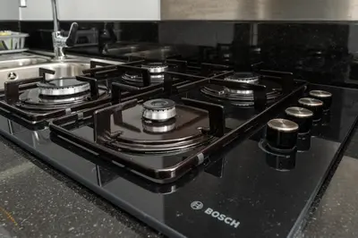 a black stove top with several burners on it at White Sage - Fancy Studio With Mesmerizing Canal Views in Dubai