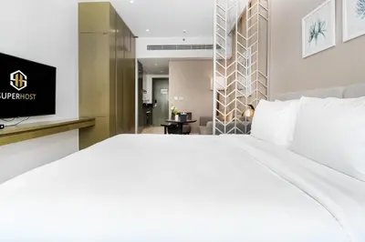 a hotel room with a large bed and a television at White Sage - Fancy Studio With Mesmerizing Canal Views in Dubai