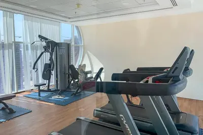a gym with tread machines and a treadmill at Frank Porter - Oasis Tower 1 in Dubai