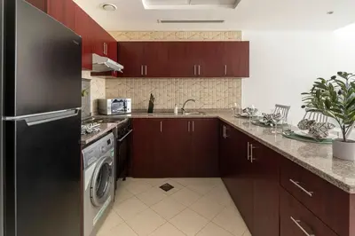 a kitchen with a refrigerator and a dishwasher at Frank Porter - Oasis Tower 1 in Dubai