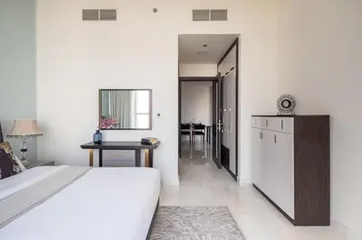 a bedroom with a white bed and a table at Frank Porter - Bayz Tower by Danube in Dubai