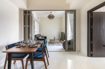 a dining room with a table and chairs and a living room at Frank Porter - Bayz Tower by Danube in Dubai