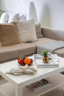 a white coffee table with fruit on it in front of a couch at Frank Porter - Concorde Tower in Dubai