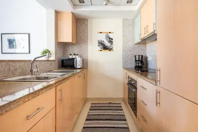 a kitchen with wooden cabinets and a sink at Frank Porter - Blakely Tower in Dubai