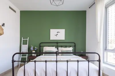 a bedroom with a green wall and a bed at Frank Porter - Blakely Tower in Dubai