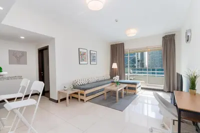 a living room with a couch and a table at White Sage - Gorgeous Apartment in JLT Near the Metro Station in Dubai