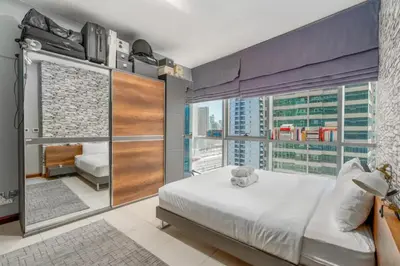 a bedroom with a large bed and a large window at Summer Deal! Stylish 1 BR in Jumeirah Lake Towers in Dubai