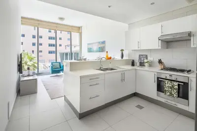 a white kitchen with a sink and a stove at Frank Porter - Panoramic Tower in Dubai