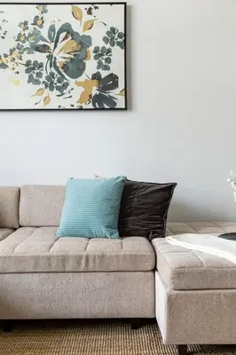 a couch in a living room with a painting on the wall at Frank Porter - Tower 108 in Dubai