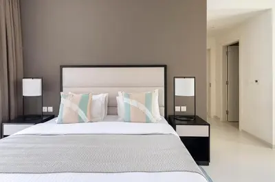 a bedroom with a large white bed with two lamps at Frank Porter - Tower 108 in Dubai