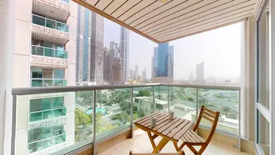 a balcony with a table and chair and a view of the city at Al Murjan - Appealing Two Bedroom in Dubai