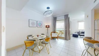 a dining room and living room with a table and chairs at Al Murjan - Appealing Two Bedroom in Dubai