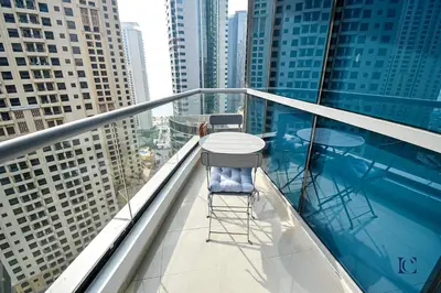 a table and two chairs on a balcony with buildings at Luxury Escapes - Spacious Studio with Balcony & Marina View - Bay Central in Dubai