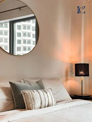 a bedroom with a bed with a mirror on the wall at Luxury Escapes - Spacious Studio with Balcony & Marina View - Bay Central in Dubai
