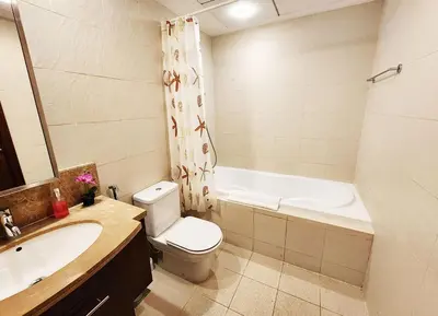 a bathroom with a toilet and a sink and a tub at RH- The Perfect Family Getaway, 3BR in Standpoint Tower in Dubai