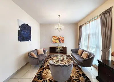a living room with a couch and a table and chairs at RH- The Perfect Family Getaway, 3BR in Standpoint Tower in Dubai