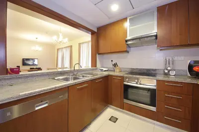 a kitchen with wooden cabinets and stainless steel appliances at RH- The Perfect Family Getaway, 3BR in Standpoint Tower in Dubai