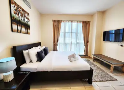 a hotel room with a large bed and a television at RH- The Perfect Family Getaway, 3BR in Standpoint Tower in Dubai