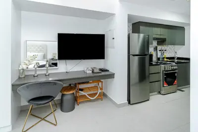 a kitchen with a desk with a tv and a refrigerator at Modern Studio with Pool & Gym Access in Dubai