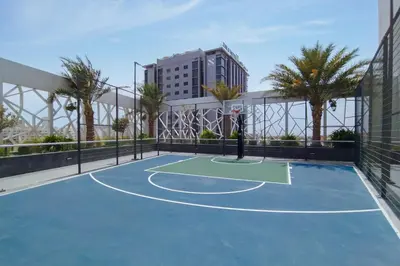 a tennis court on a balcony with palm trees at Modern Studio with Pool & Gym Access in Dubai