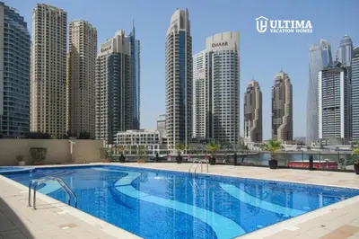 a large swimming pool in front of a city skyline at Alluring 1BR Opp to JBR Beach- Marina Views in Dubai