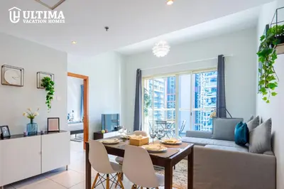 a living room with a table and a couch at Alluring 1BR Opp to JBR Beach- Marina Views in Dubai