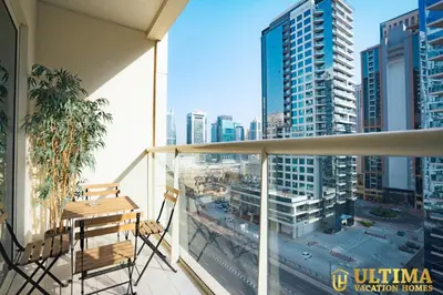 a balcony with a table and chairs and a view of a city at Alluring 1BR Opp to JBR Beach- Marina Views in Dubai