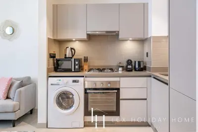 a kitchen with a washing machine and a microwave at LUX The Executive Sobha Suite 2 in Dubai