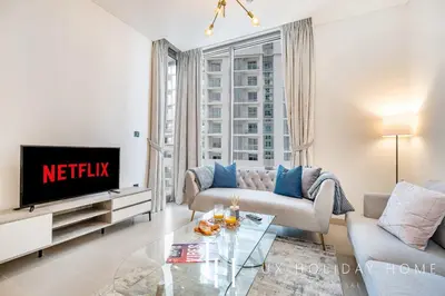 a living room with a couch and a tv at LUX The Executive Sobha Suite 2 in Dubai