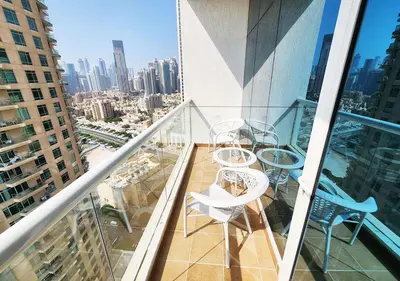 a balcony with tables and chairs on a building at RH- Contemporary & Comfortable, Studio near Dubai mall in Dubai