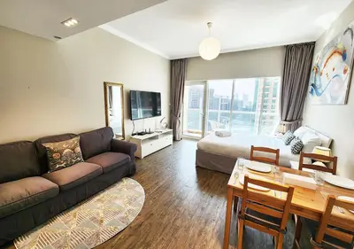 a living room with a couch and a bed and a table at RH- Contemporary & Comfortable, Studio near Dubai mall in Dubai
