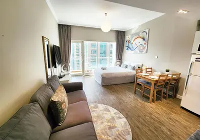 a living room with a couch and a bed and a table at RH- Contemporary & Comfortable, Studio near Dubai mall in Dubai