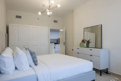 a bedroom with a white bed and a mirror at 1BDR Apartment I Close To Metro I Marina Diamond 4 in Dubai